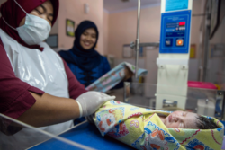 A newborn being examined by nurses in Indonesia
