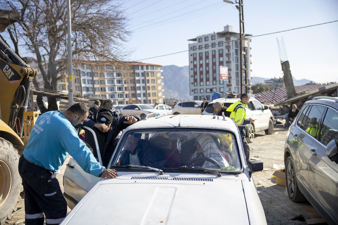 A white car stopped by officials as they pass along the rubble in Turkey.