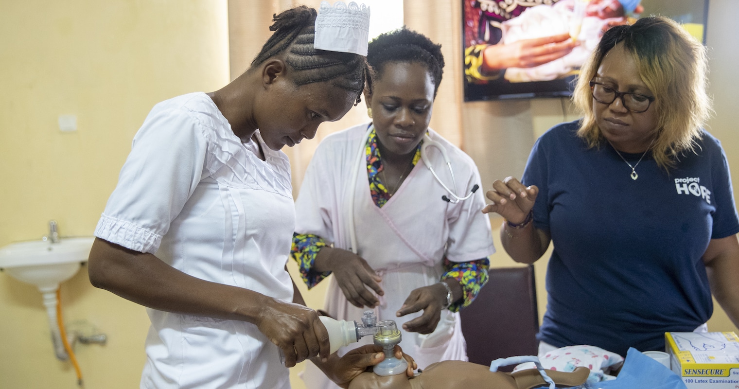 Two nurses in Sierra Leone learning how to care for child.