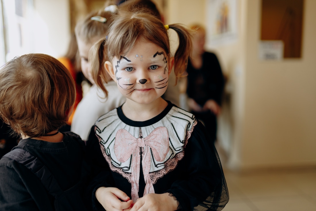 little girl looks at camera with face paint on