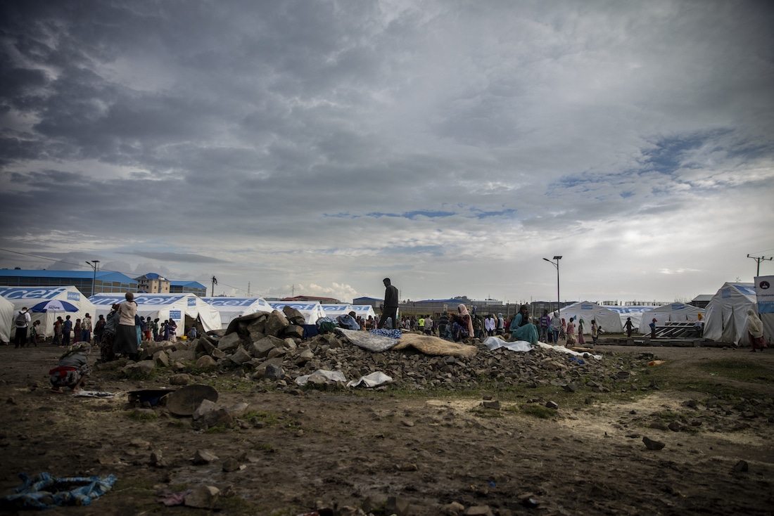 shadow of man standing on top of rubble in refugee camp
