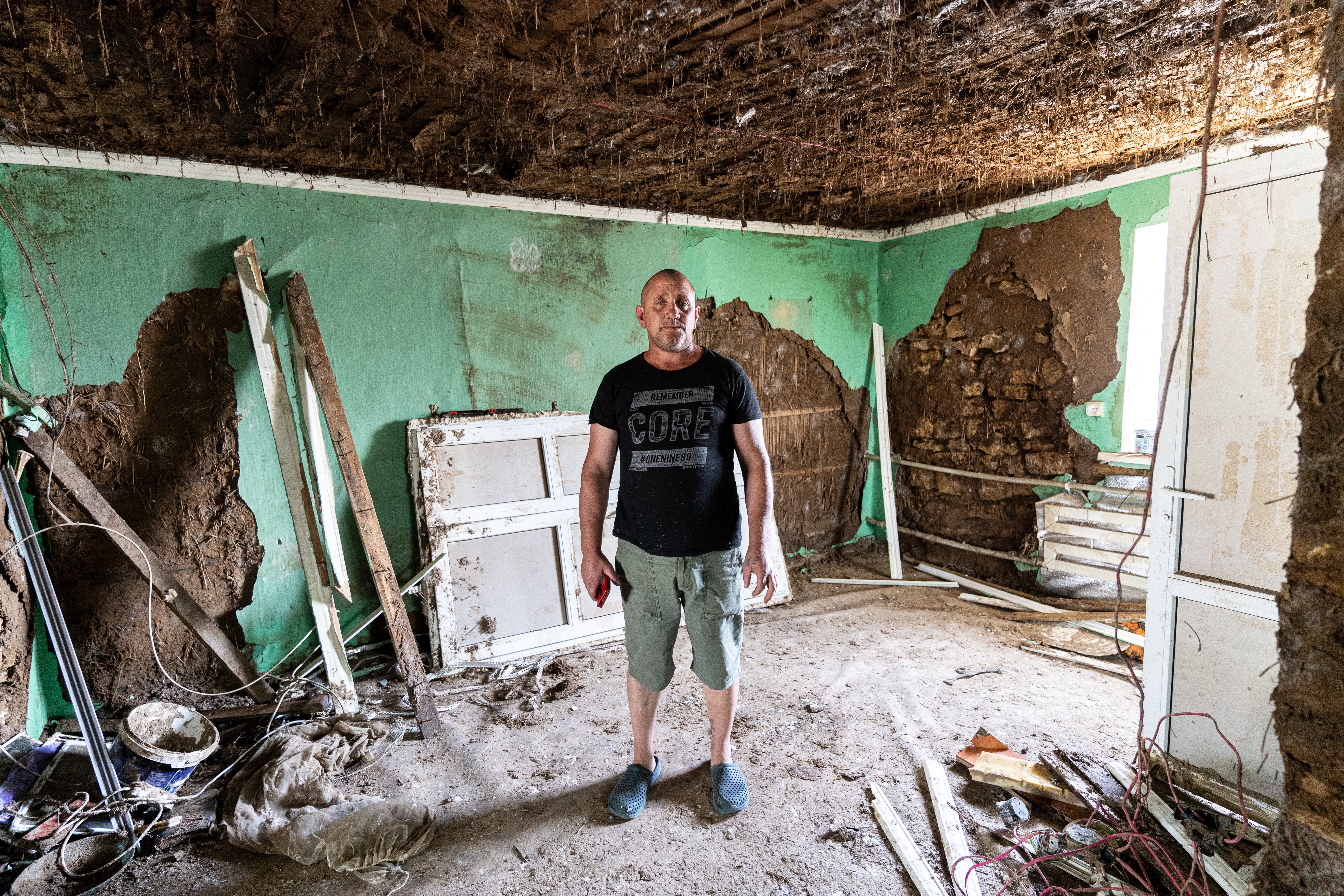 man standing in the middle of a damaged house