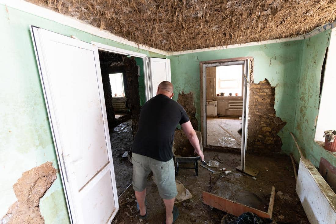 man walking through destroyed home in Ukraine