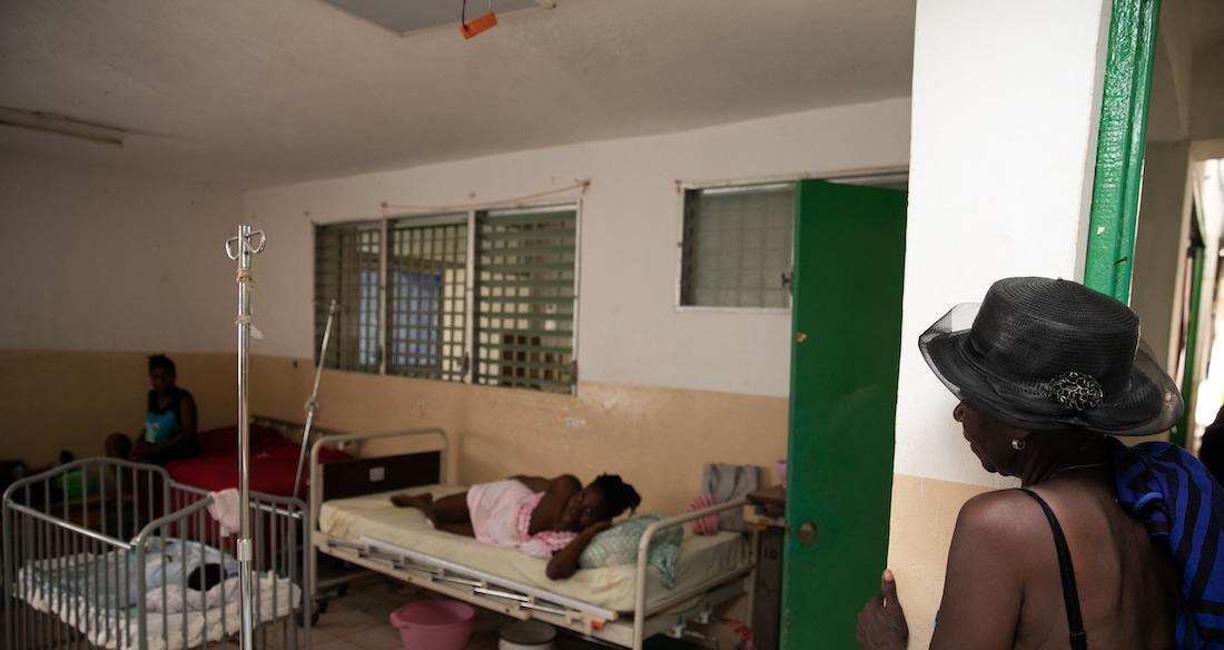 woman checking in on patient in hospital in Haiti