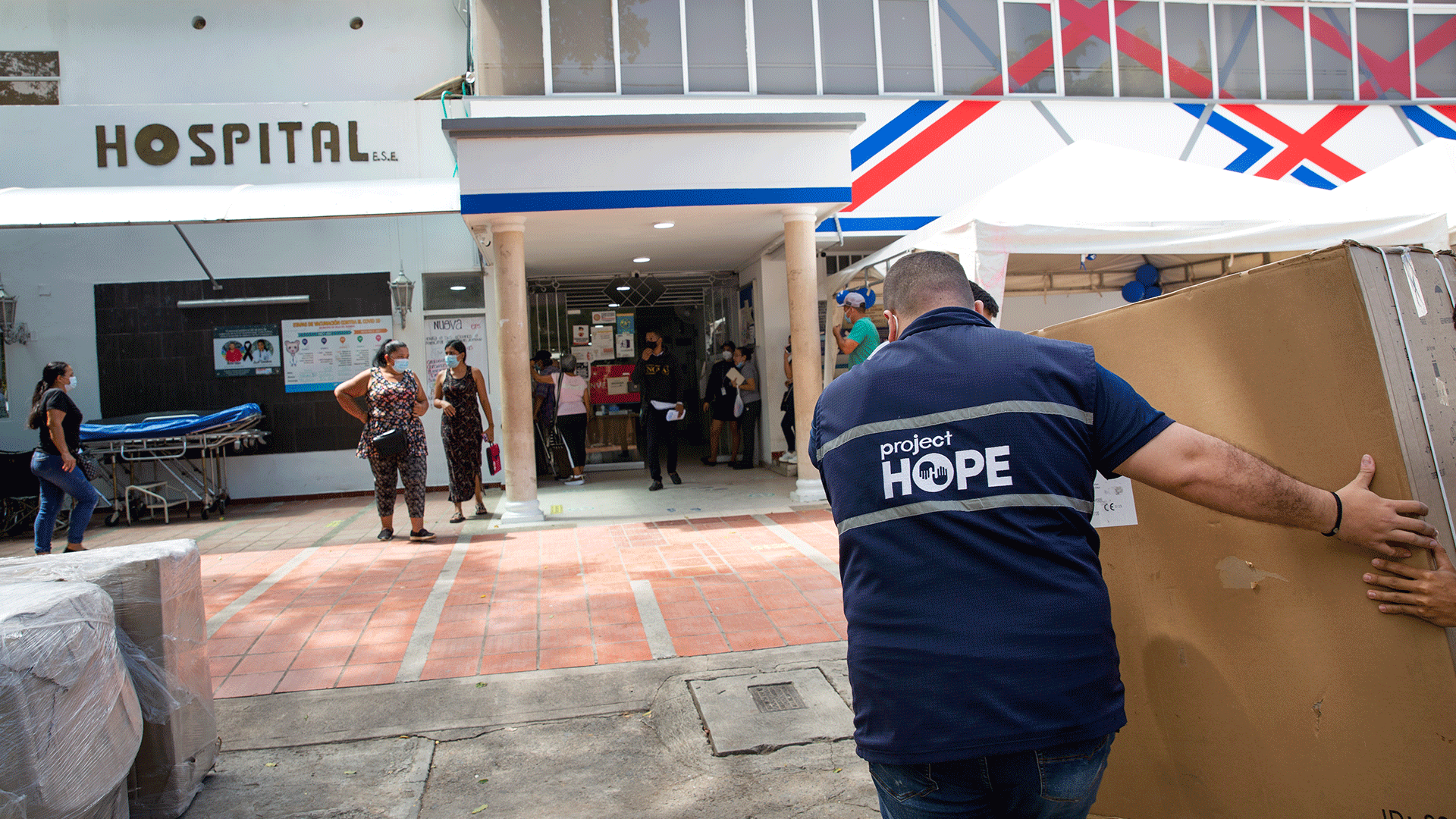 a man carrying medical equipment into a hospital in Colombia