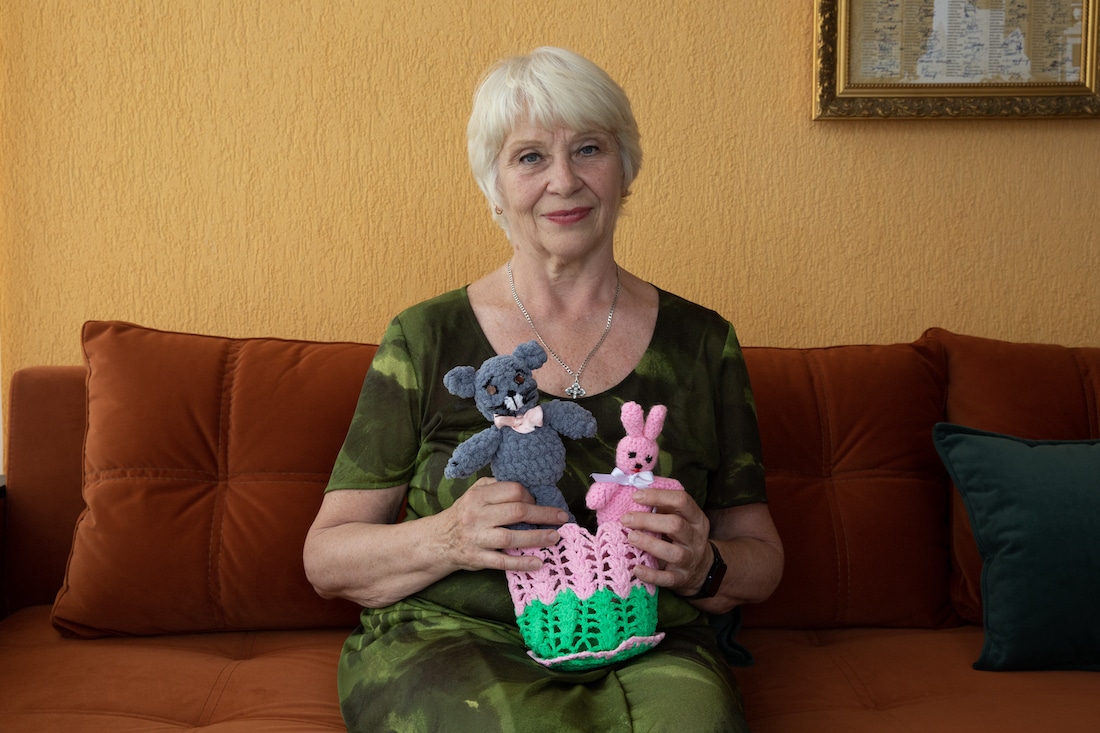 elderly woman holds stuffed animals