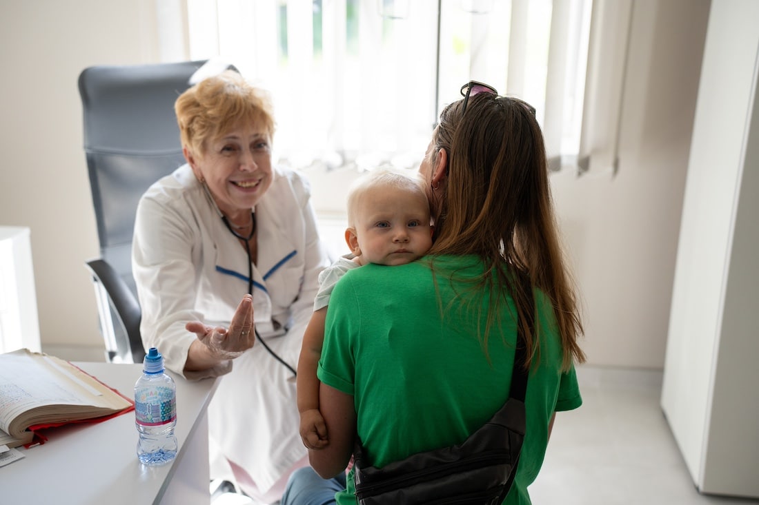 The first patient at the hospital in Ukraine is a young child being held by their mother.