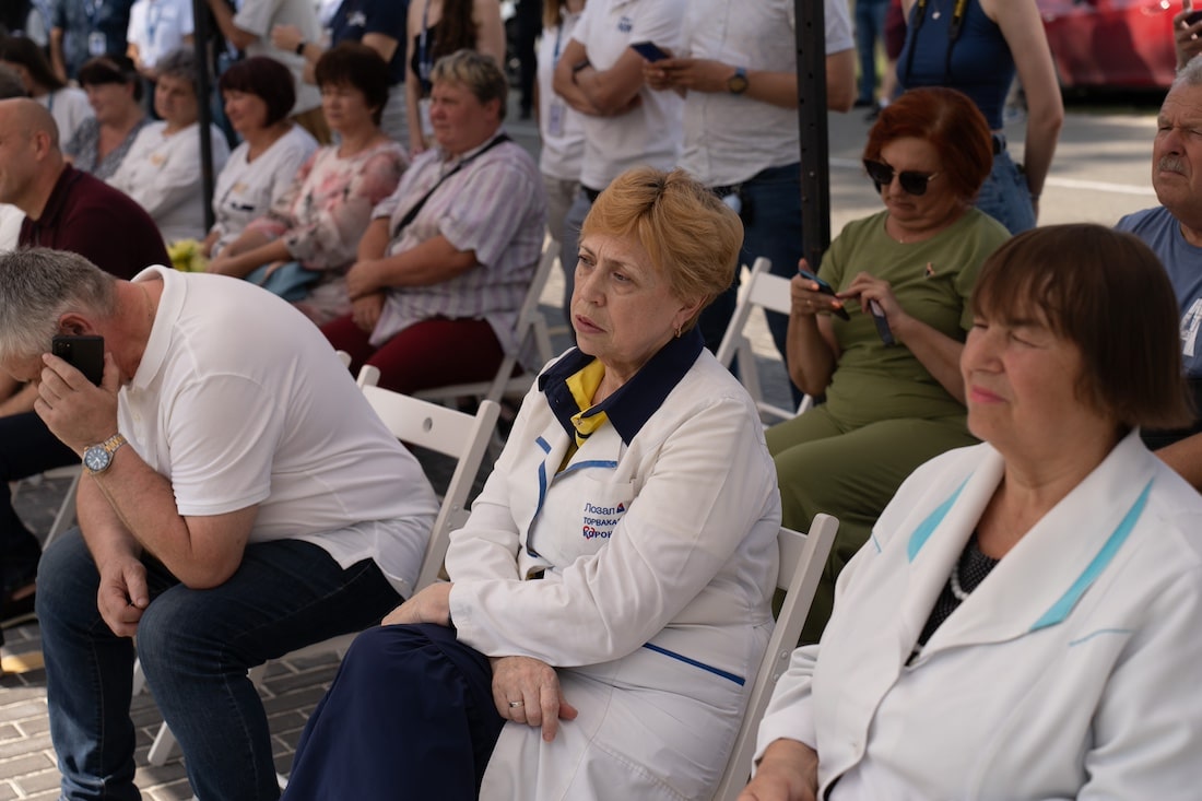 Various people in hospital coats sitting together at an event
