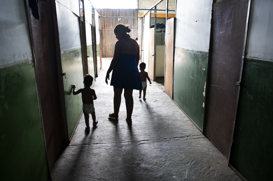 woman walking with children in hallway