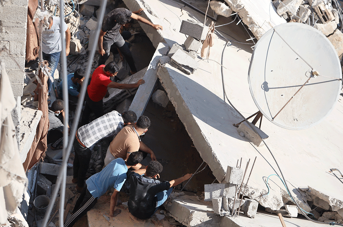 A group of men going through the rubble in a collapsed building in Gaza.