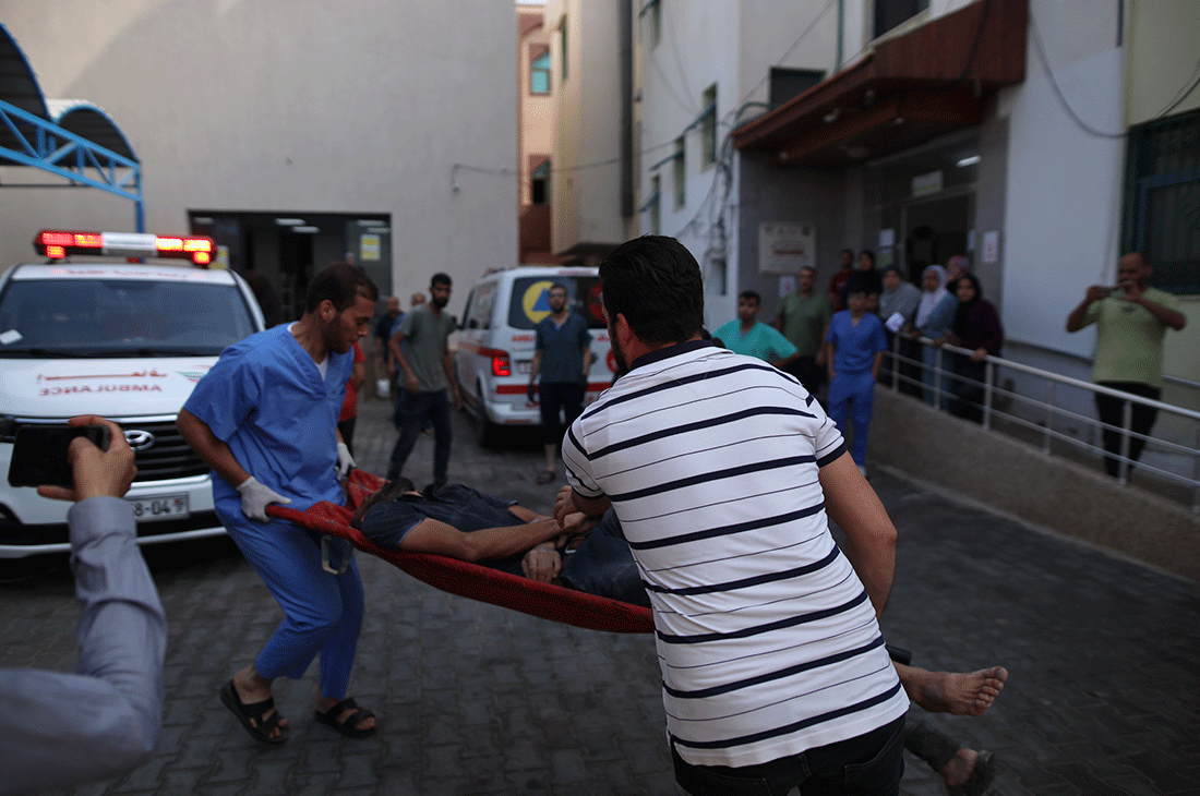 Two men carrying a body on a stretcher in Gaza