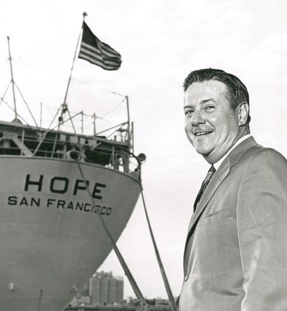 man smiling in front of ship