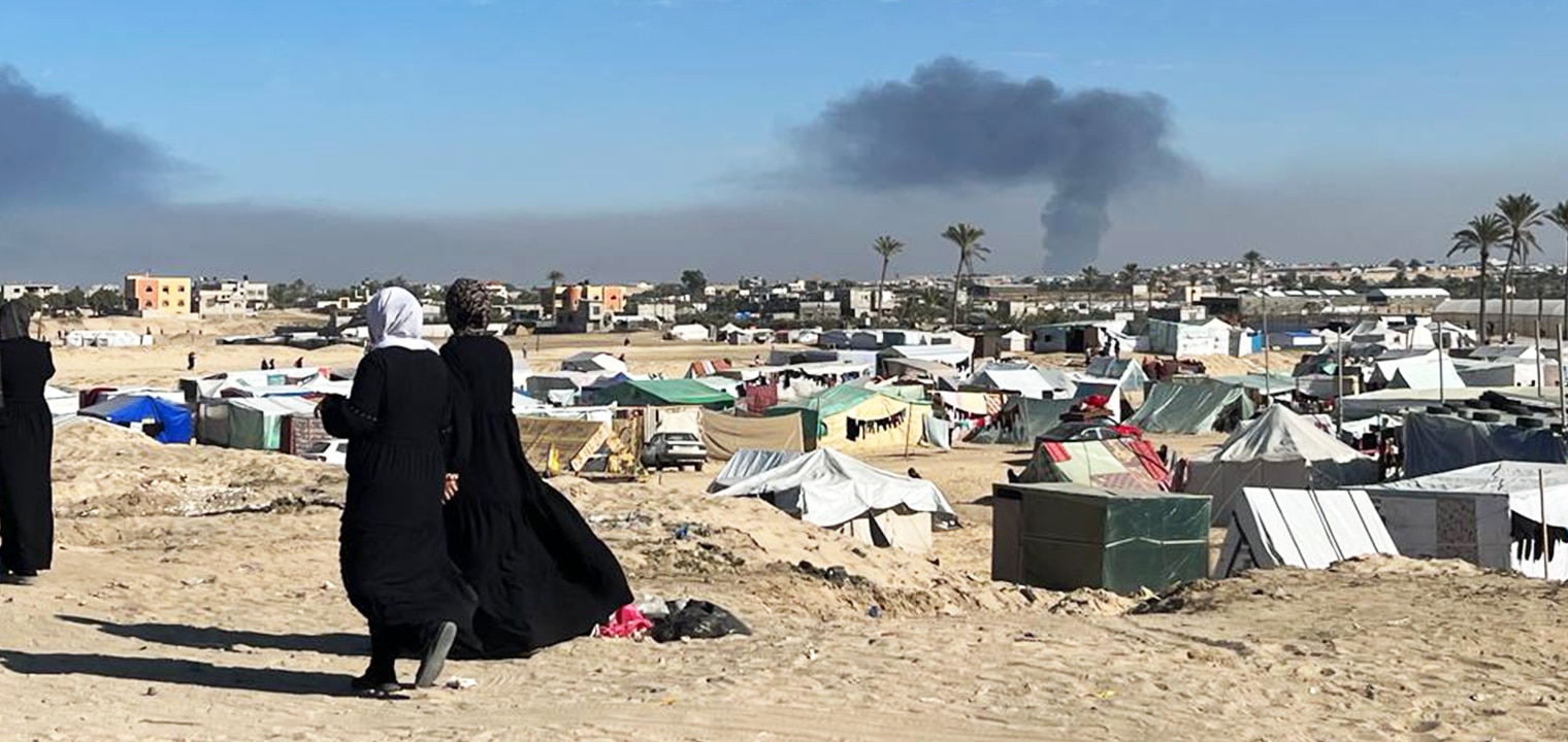 explosion in the background of Gaza where families are camped out