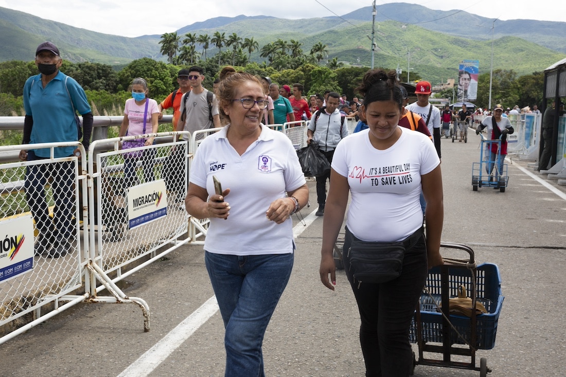 two women in white shirts crossing over the Colombia/Venezuela border