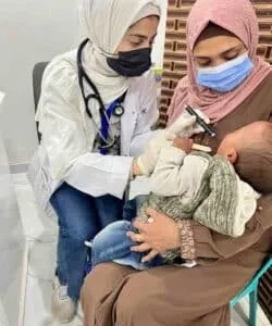 Woman doctor check on newborn in Gaza