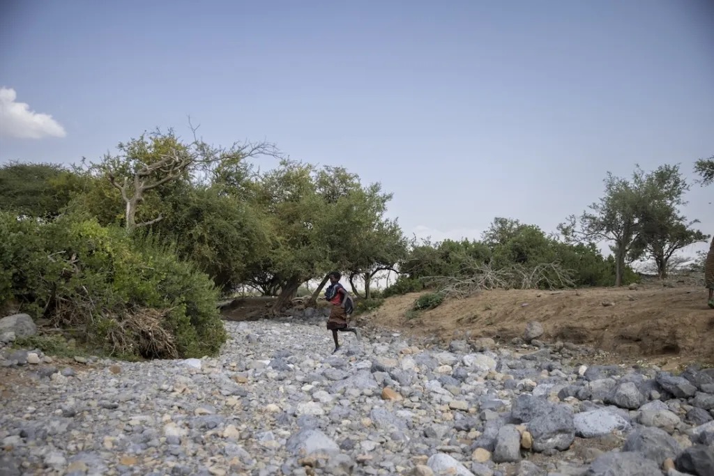 young child runs across dried up river