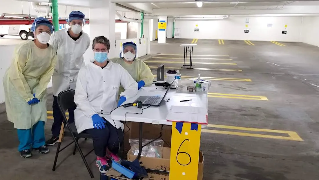 group of health workers in PPE working a COVID-19 vaccine site
