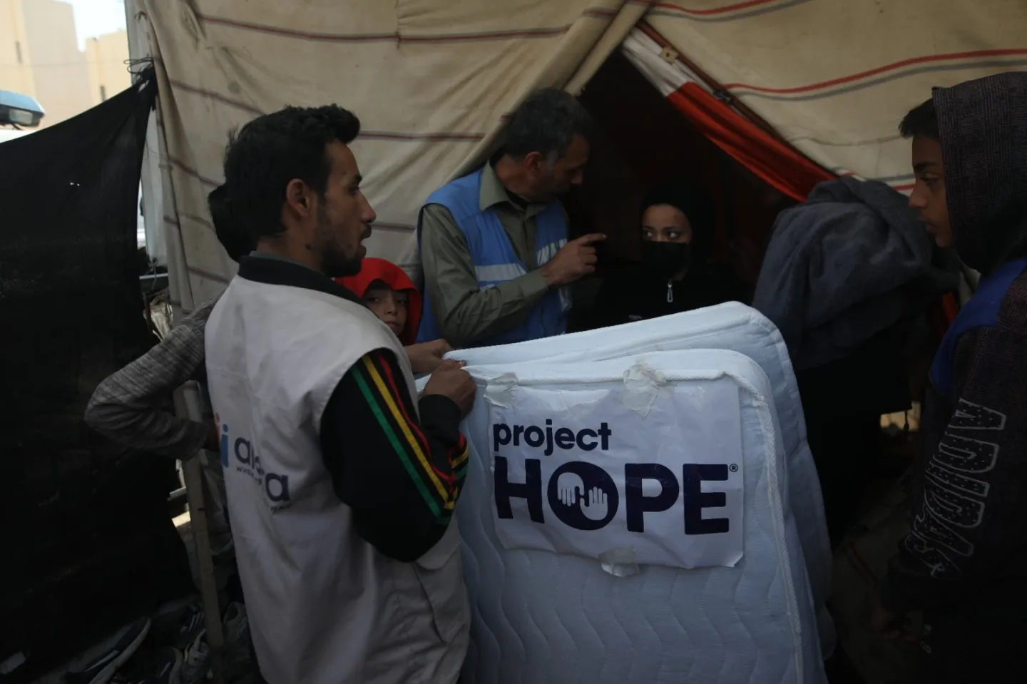 A man drops off a mattress to a camp in Gaza