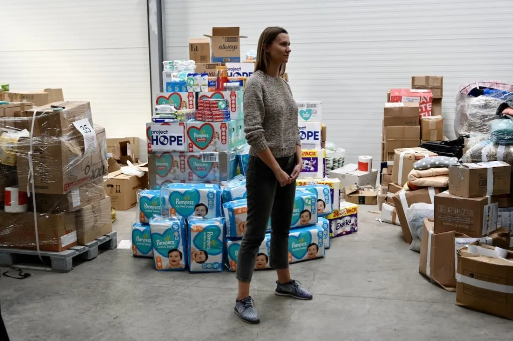 Ukrainian refugee in front of supplies in shelter