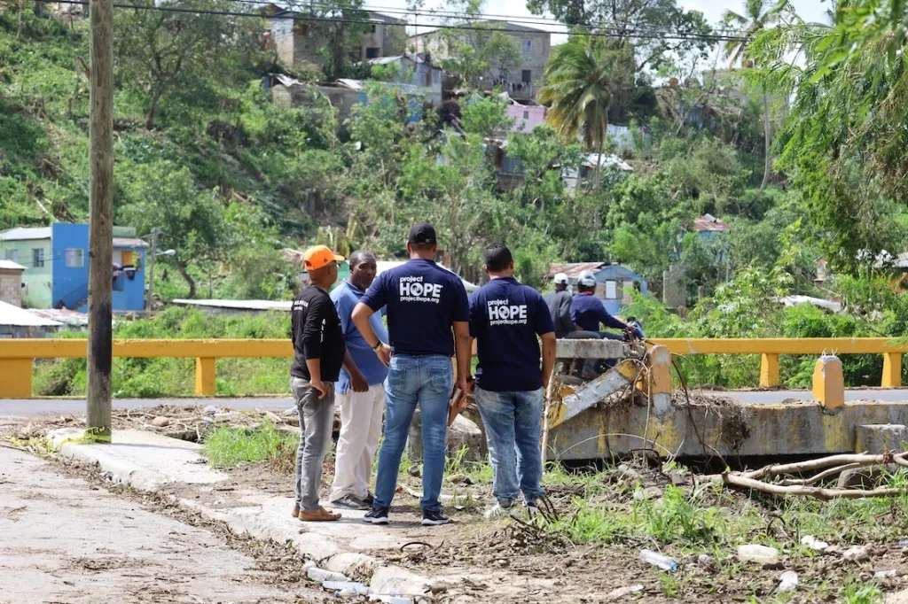 men standing by damaged bridge in the Dominican Republic