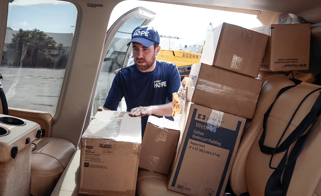 Man loading boxes onto a car.