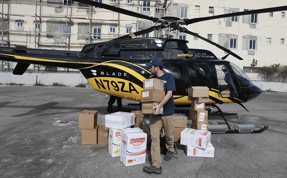 man carrying packages from helicopter