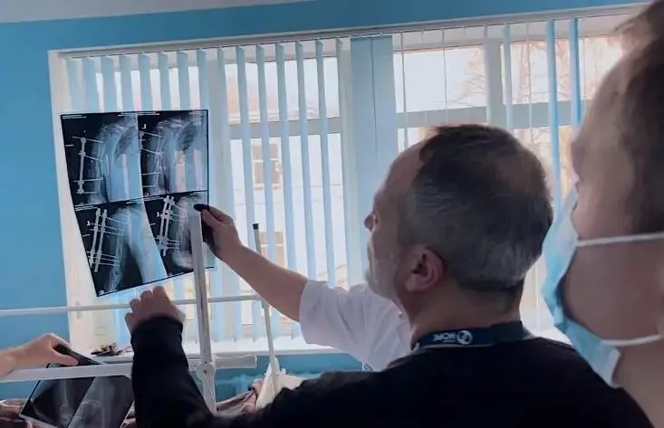 behind the back shot of a man looking at an x-ray