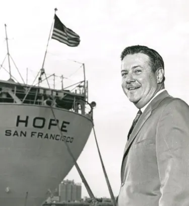man smiling in front of ship
