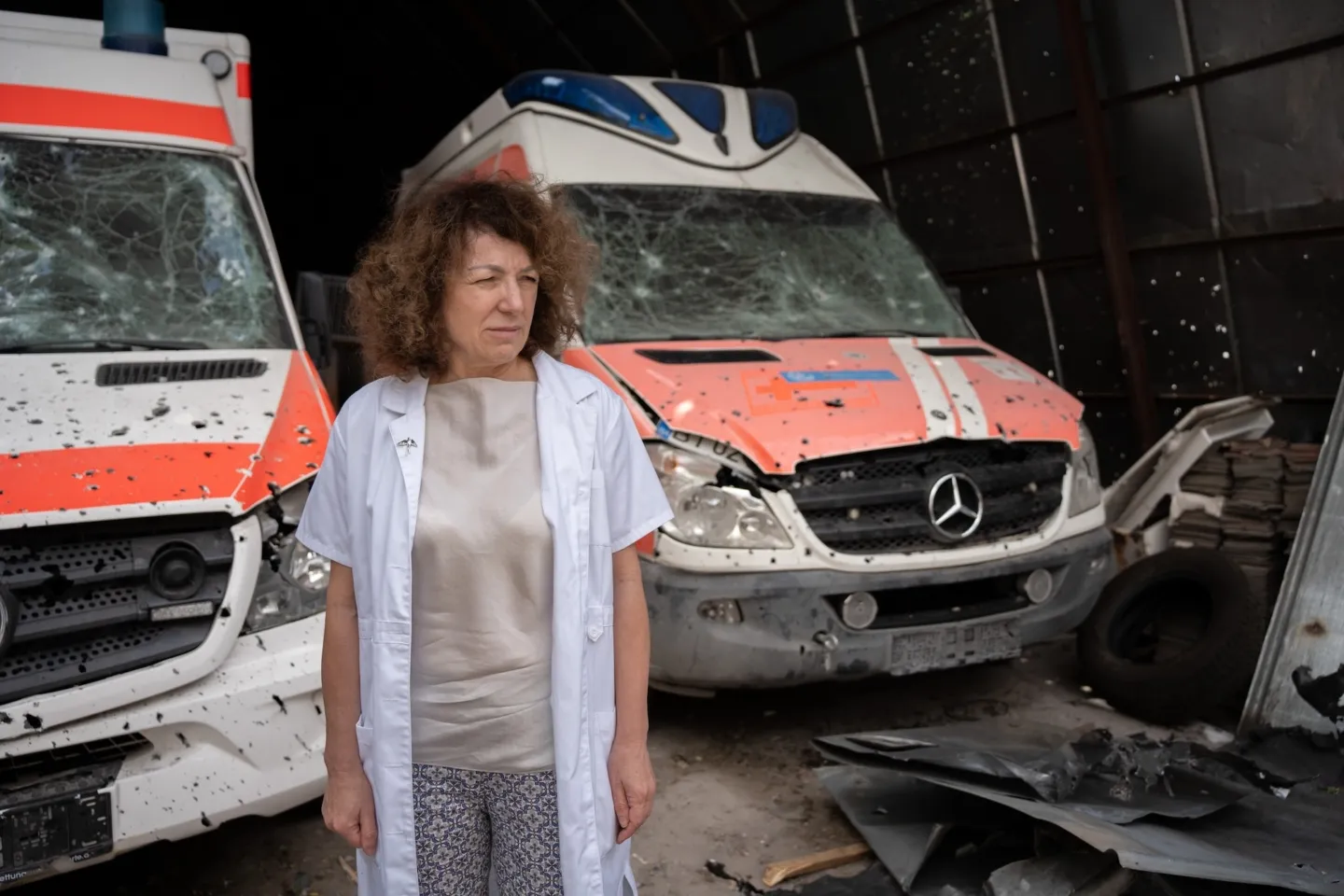 medical staff stands in front of destroyed ambulances in Ukraine