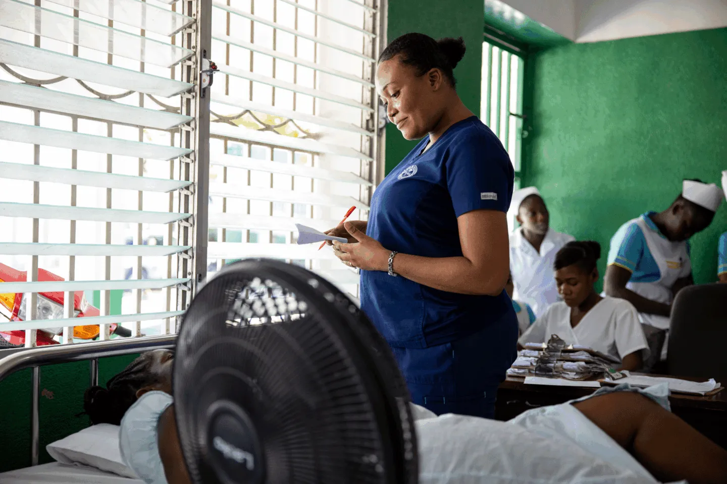 woman checks in on patient in hospital in Haiti