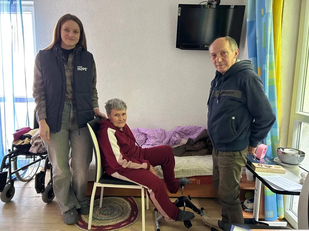 a woman stands with an elderly couple