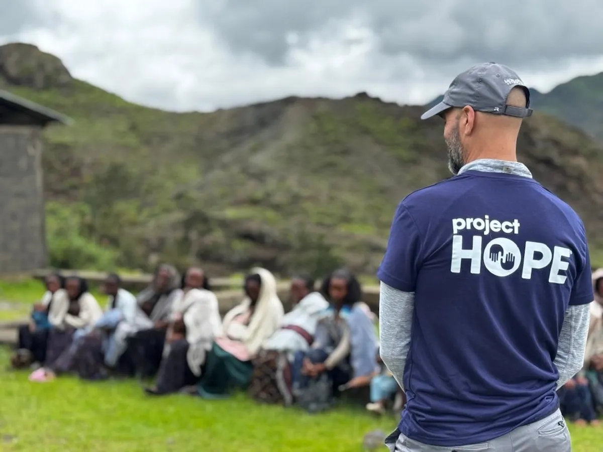 A Project HOPE staffer standing alongside patients in Ethiopia