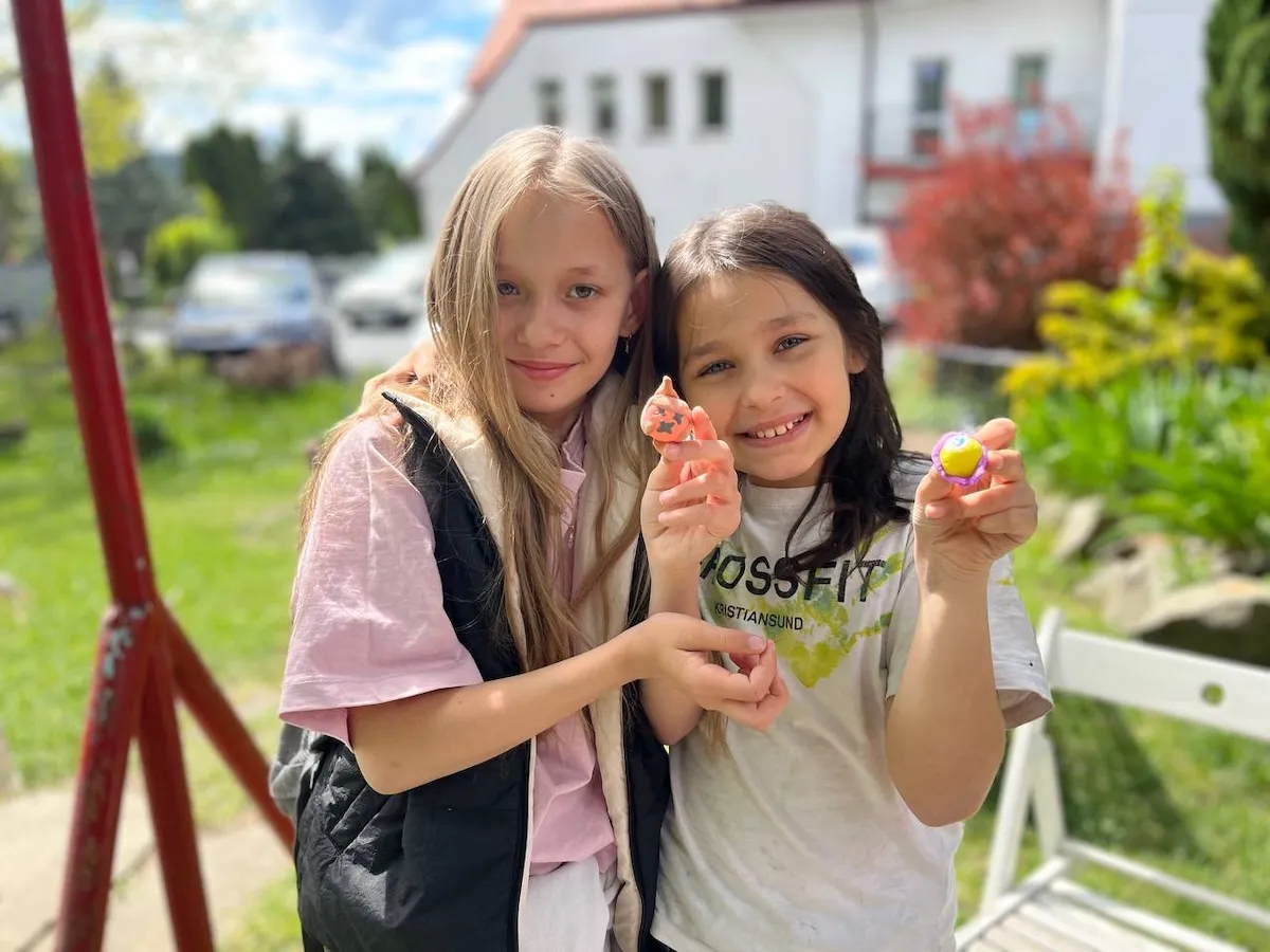 Two young girls sharing their art pieces in Poland