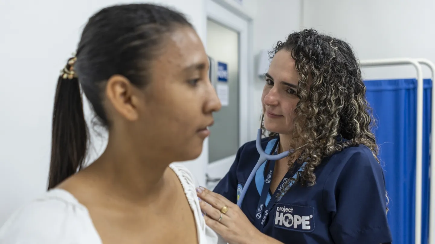 medical staff member listens to the lungs of a patient in Colombia