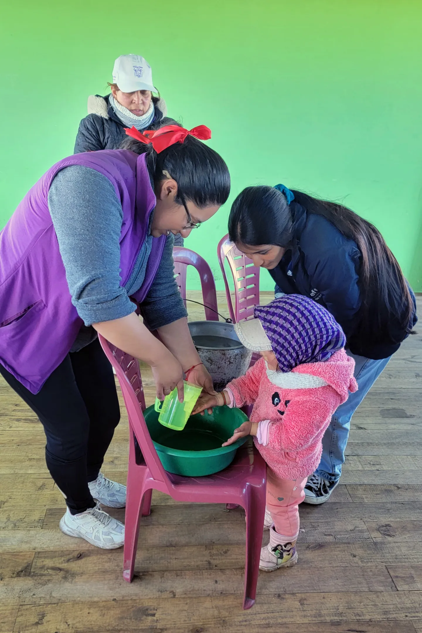 young girl learns WASH with community members in Ecuador