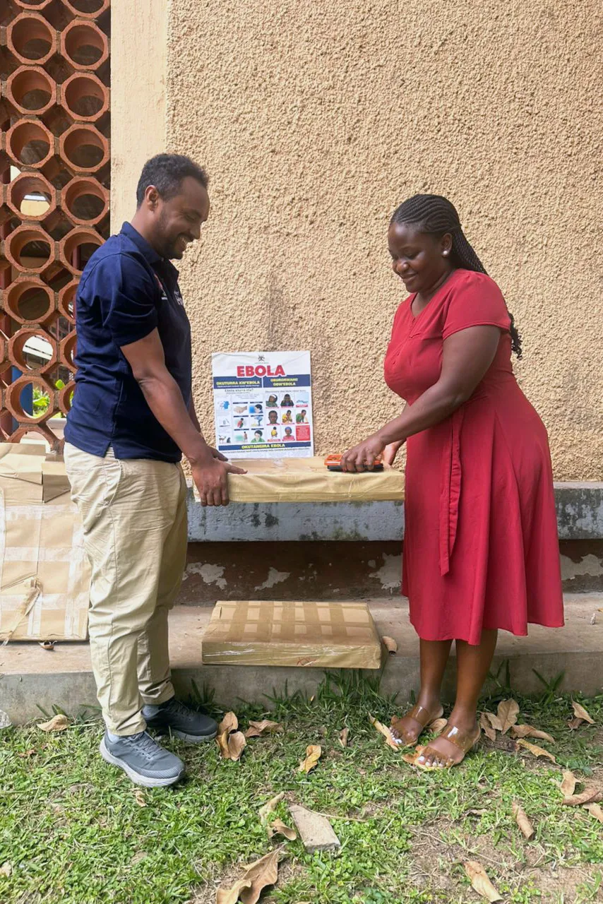 A man and woman carrying communication material on Ebola to medical center in Uganda
