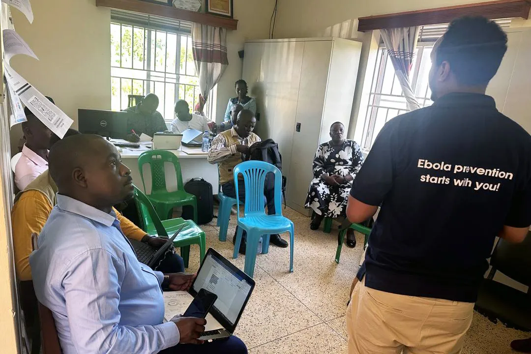 group of folks sitting in a room discussing Ebola response needs in Uganda