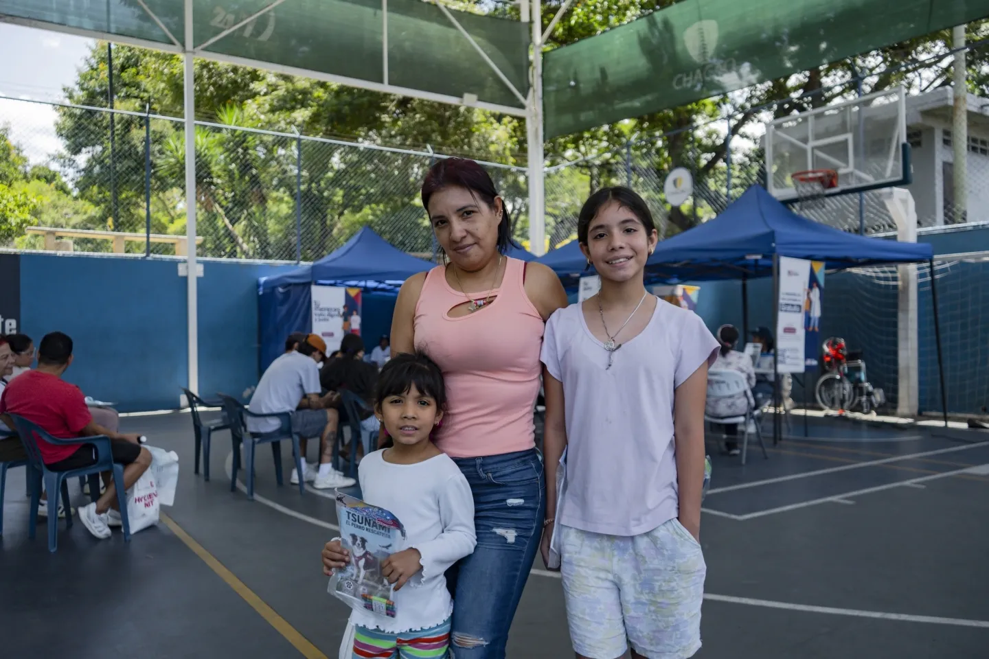 mother and her two daughters standing together at popup clinic in Venezuela