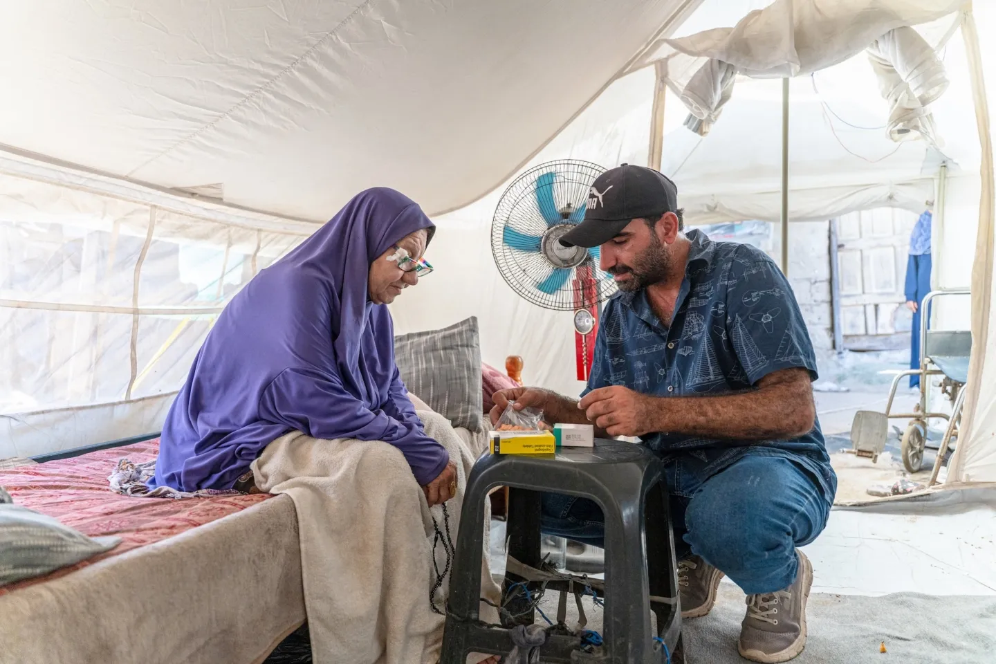 man gives medication to mother in Gaza