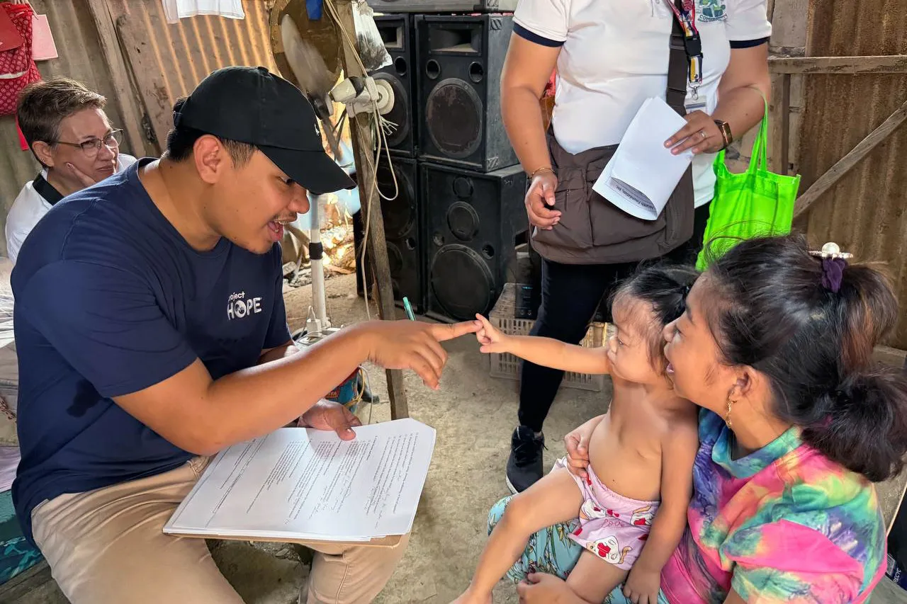 Project HOPE staff member plays with young child in the Philippines