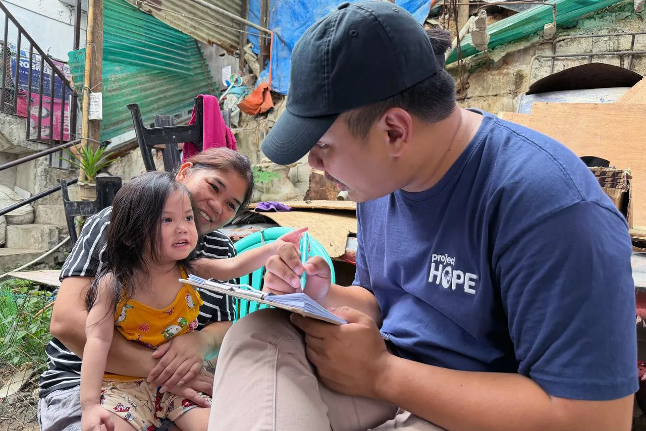 Project HOPE staff member plays with young child in the Philippines