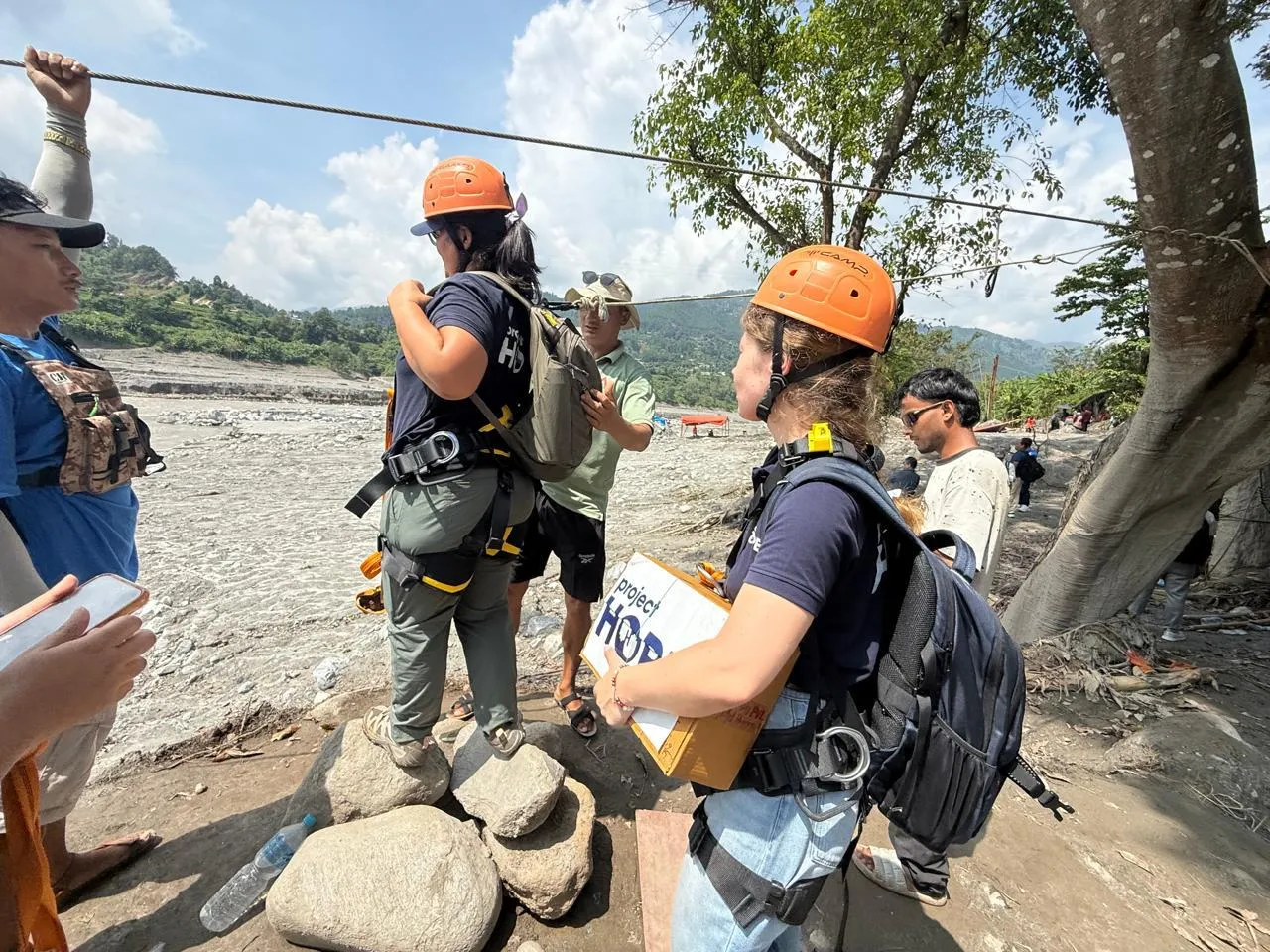 Two Project HOPE humanitarians prepare to zipline across river to deliver medical needs to those impacted by the floods in Nepal.
